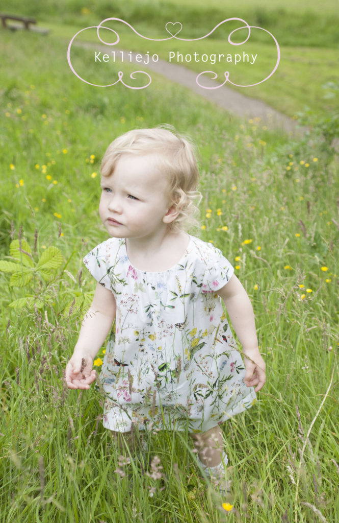 Cheshire children's photography of a little girl in the tall grass at Abney Hall Park.