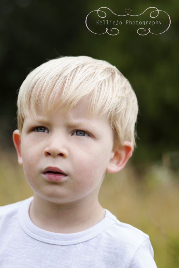 Children's photography of a young boy looking thoughtfully into the distance.