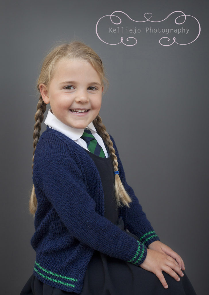 A school photograph of a primary school girl but long plaits and a big smile