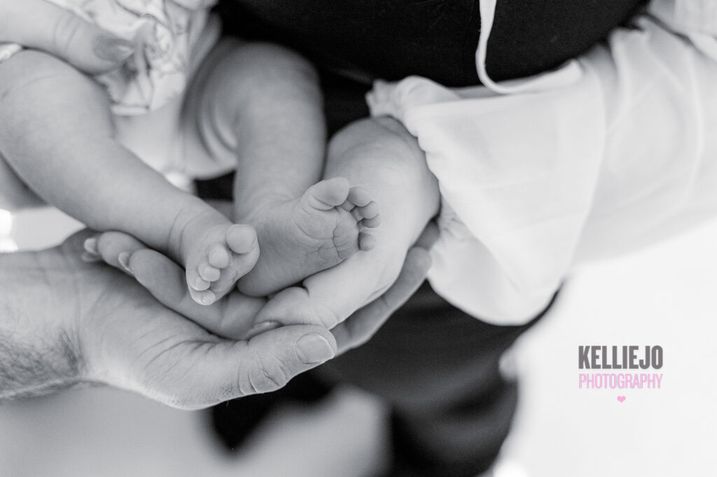 Mother and father cradling their newborn feet during a newborn photoshoot at home in Handforth